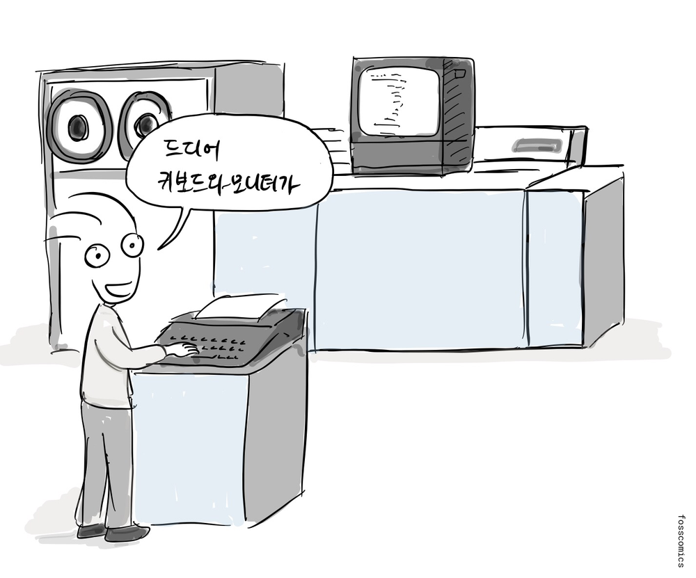 프로그래머가 테이프 릴과 화면, 프린터가 달린 대형 컴퓨터 옆에서 키보드를 사용하며 미소 짓는다.
