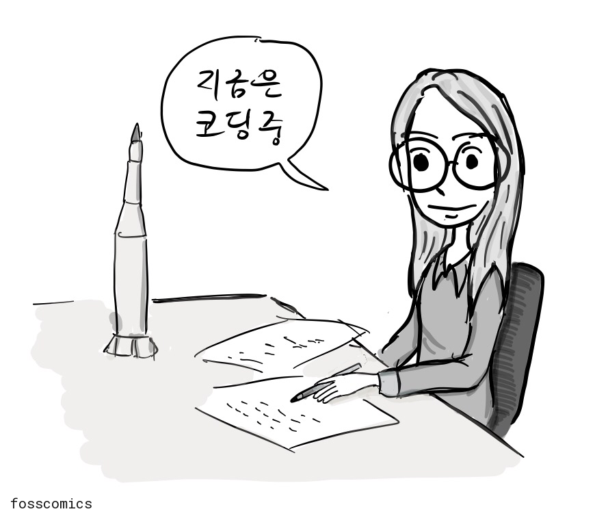 프로그래머가 모형 로켓을 옆에 두고 책상에서 종이에 코드를 쓴다.