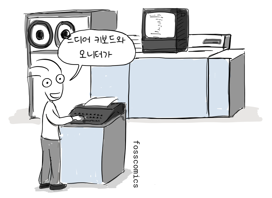 프로그래머가 테이프 릴과 화면, 프린터가 달린 대형 컴퓨터 옆에서 키보드를 사용하며 미소 짓는다.