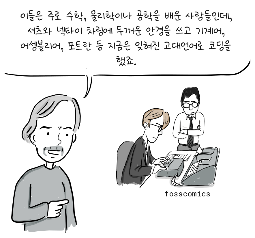 레이몬드가 대형 콘솔에서 일하는 정장 차림의 프로그래머 두 명을 가리킨다.
