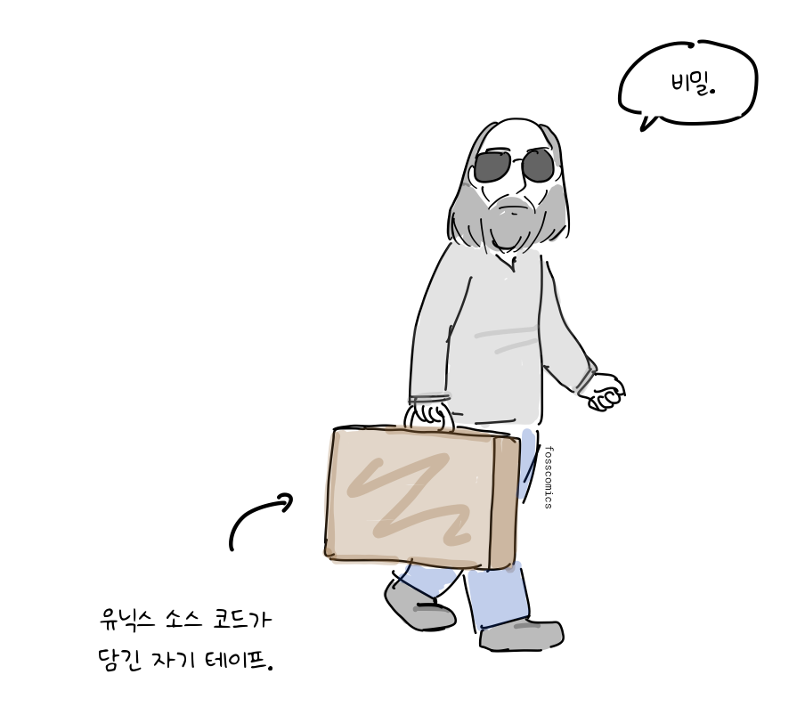 선글라스를 쓴 프로그래머가 손잡이 달린 상자를 들고 간다.