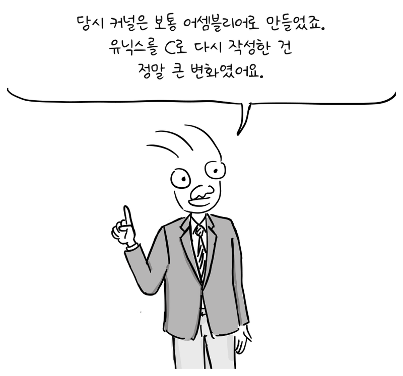 정장을 입은 발표자가 손가락 하나를 들고 어셈블리어에서 C로 전환한 일을 설명한다.