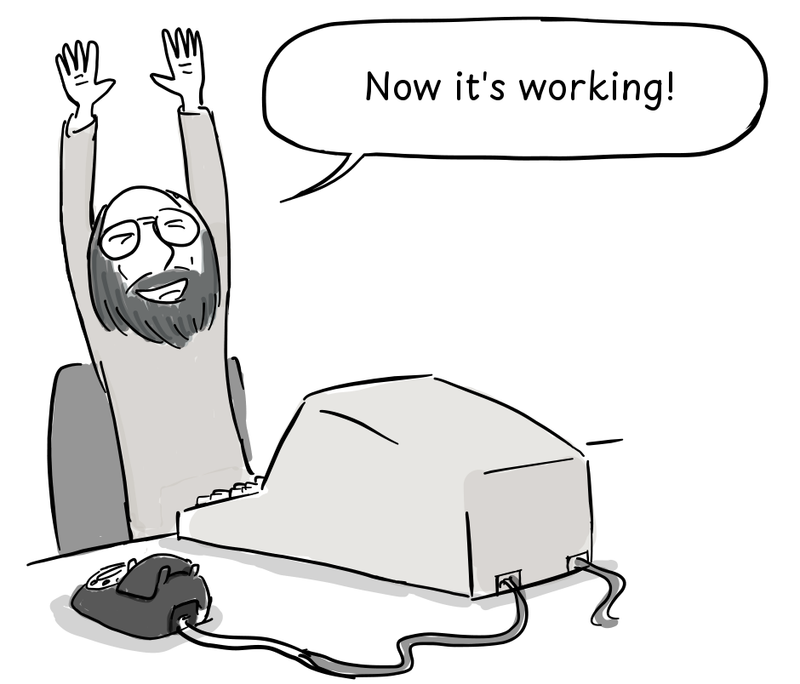 Thompson raises both arms in celebration at his computer, with a telephone connected by a cable on the desk.