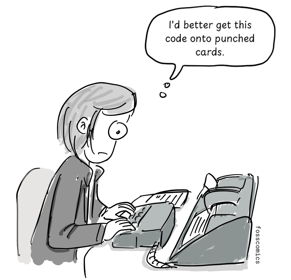 A programmer types at a keypunch machine while a punched card feeds through it.