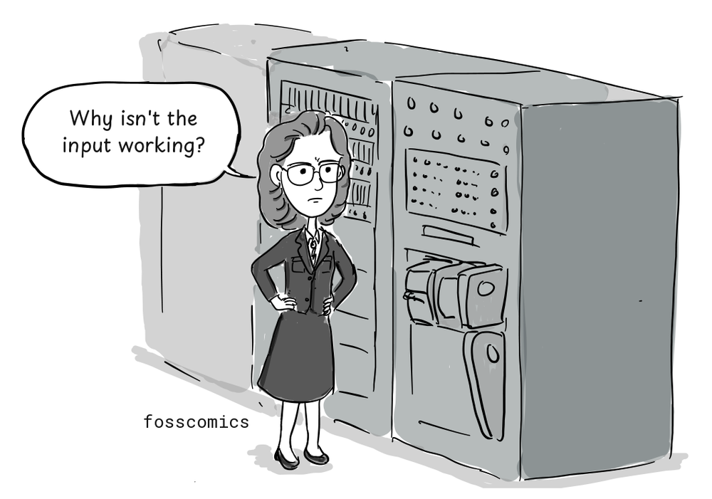 Grace Hopper stands with her hands on her hips beside the malfunctioning Harvard Mark II.